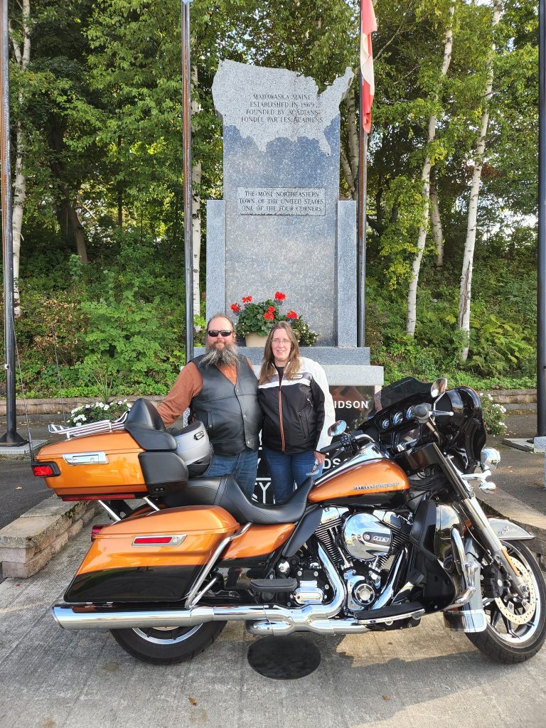 Biker couple in front of the memorial for Madwaska, Maine, as the most northeastern town in the United States